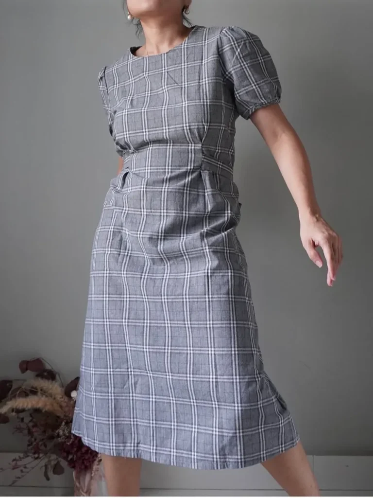 Gray plaid dress with puffed sleeves and a self tie ribbon at the back