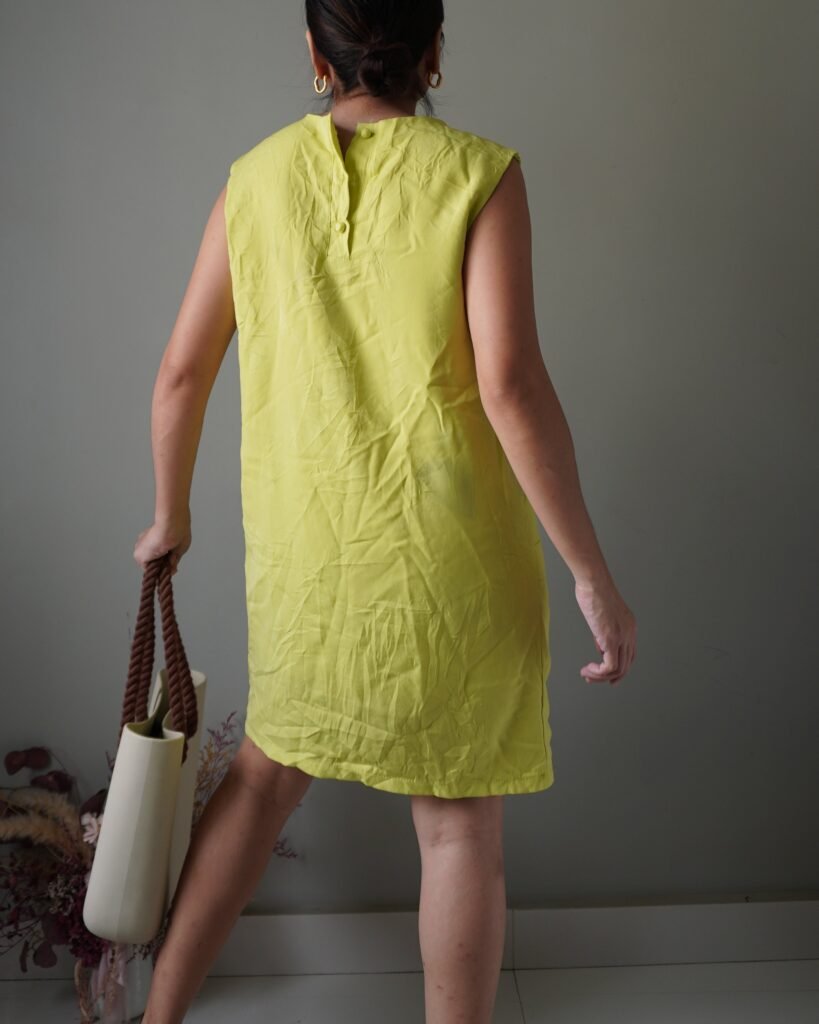 Bright yellow edgy dress with front pockets, has a bluish discoloration