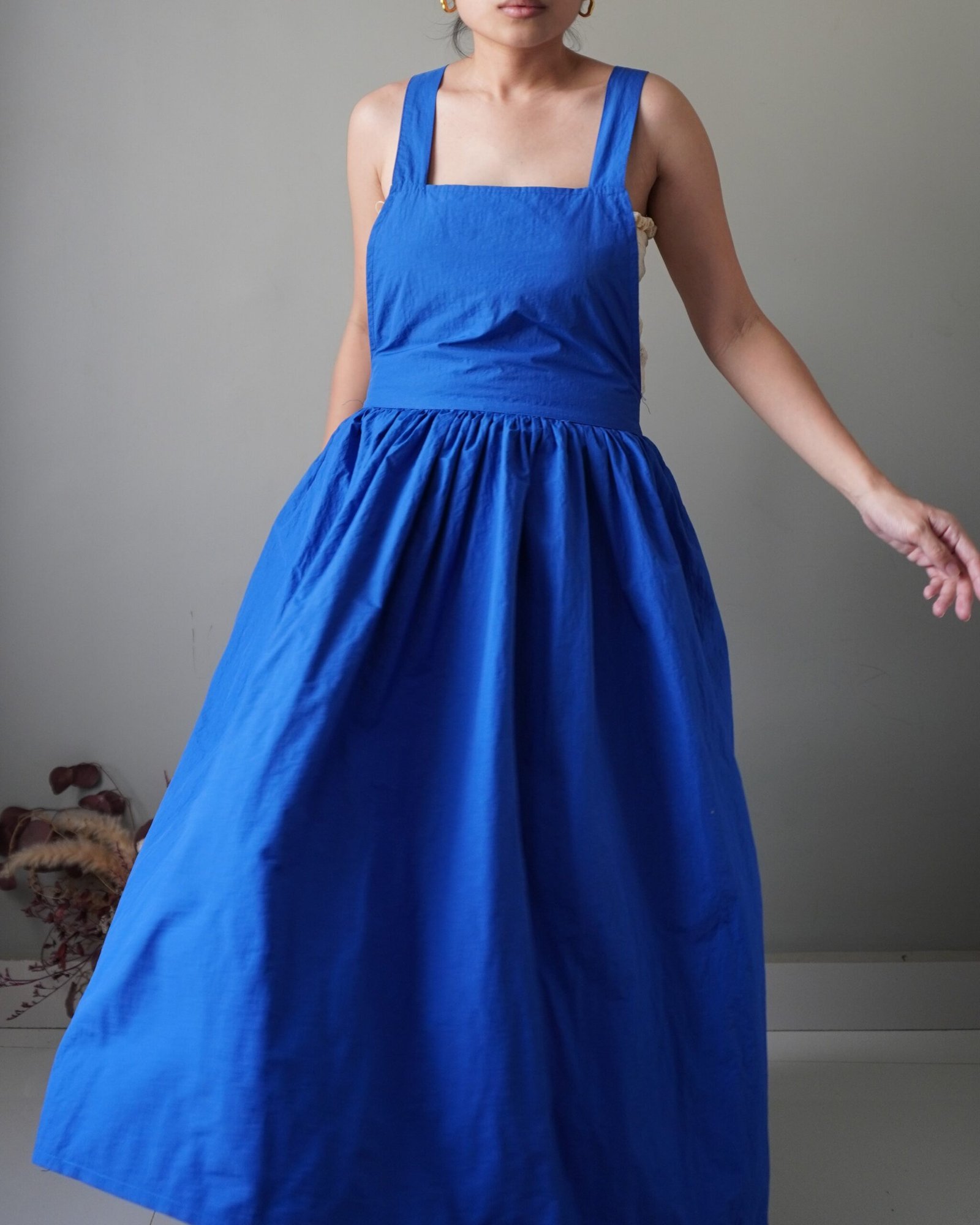 Solid crayola blue pinafore with pockets and crisscross back detail - Image 1
