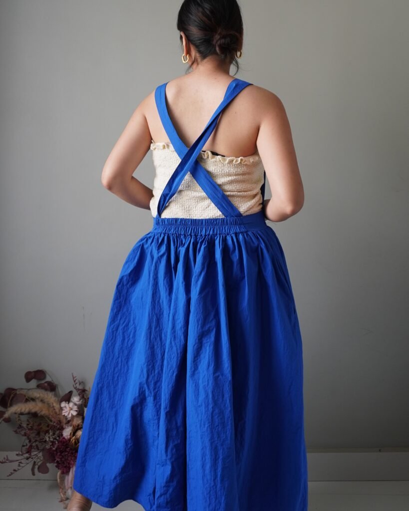 Solid crayola blue pinafore with pockets and crisscross back detail