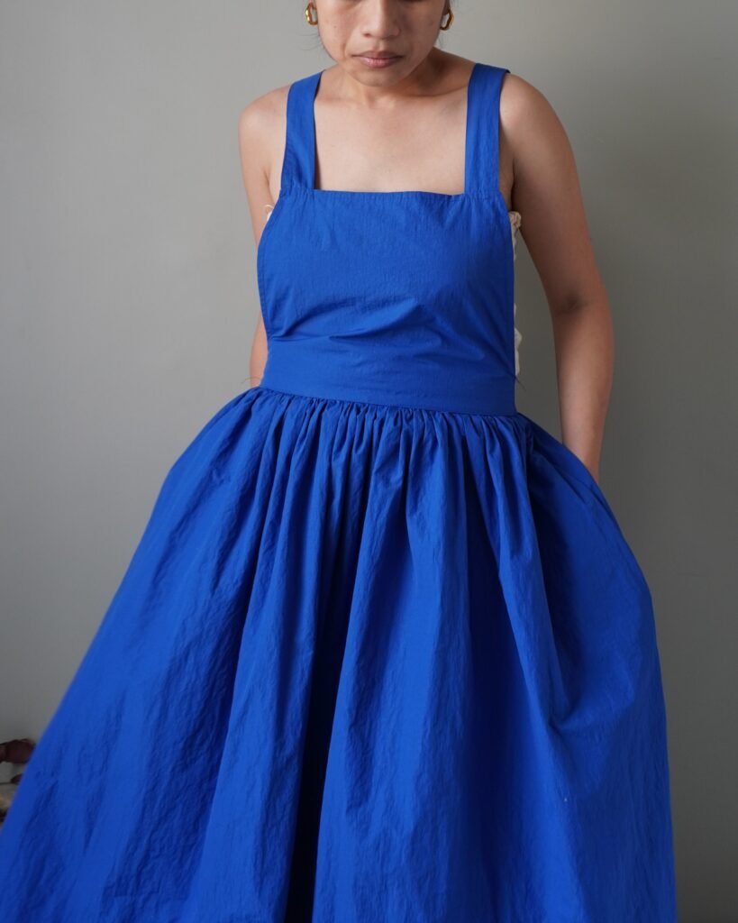 Solid crayola blue pinafore with pockets and crisscross back detail
