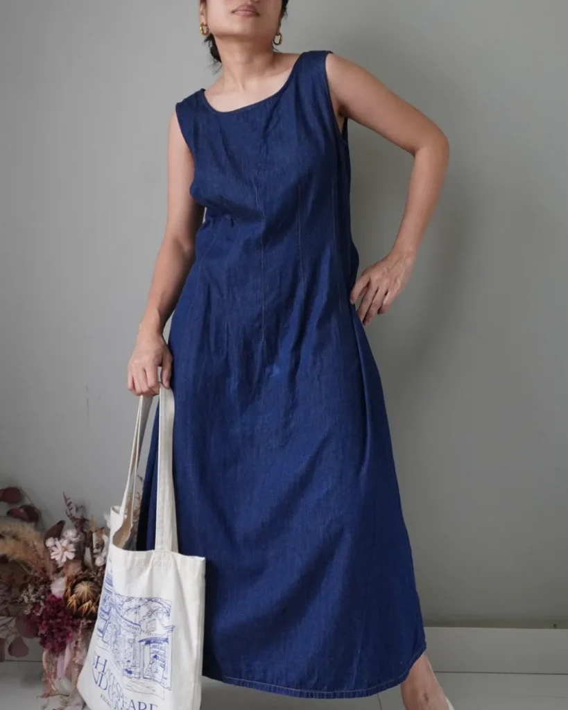 Old-fashioned denim sleeveless dress with back zipper, has a washed area. See photo for reference
