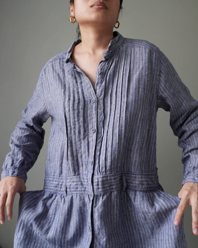 Blue striped pattern dress with button down details, cozy long sleeves and pleat accents
