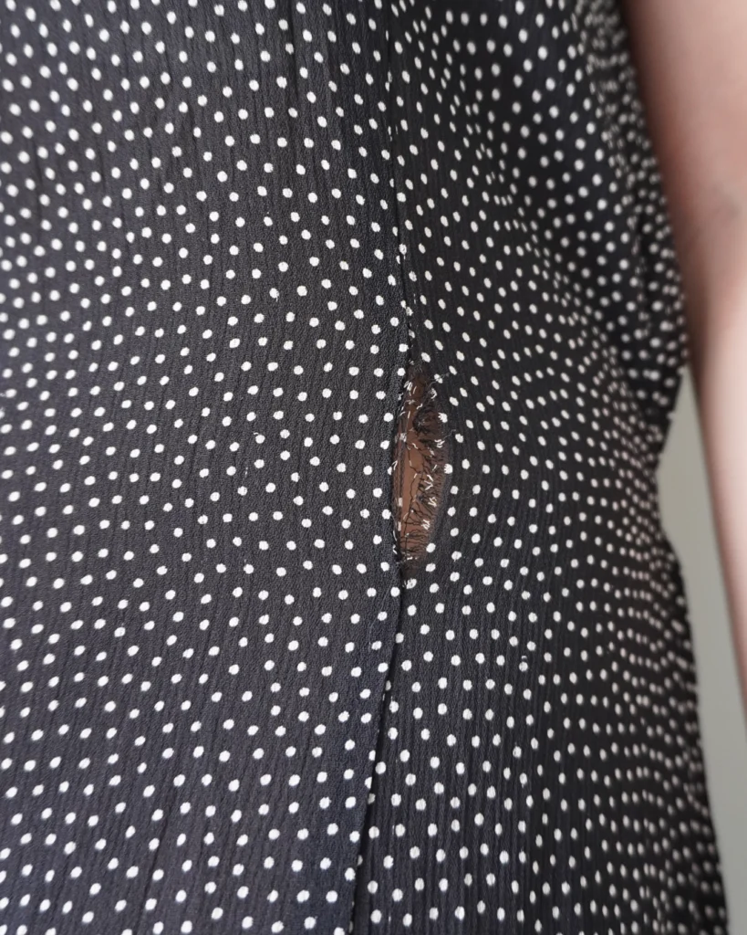 Black polka patterned dress with back zipper and ribbon that ties to the back, has few removed hems that’s reworkable